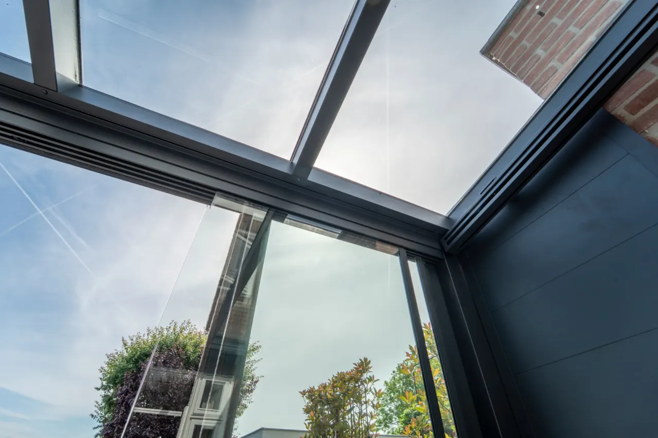 Detailopname van het glazen dak en aluminium frame van de Aluxe Trendline